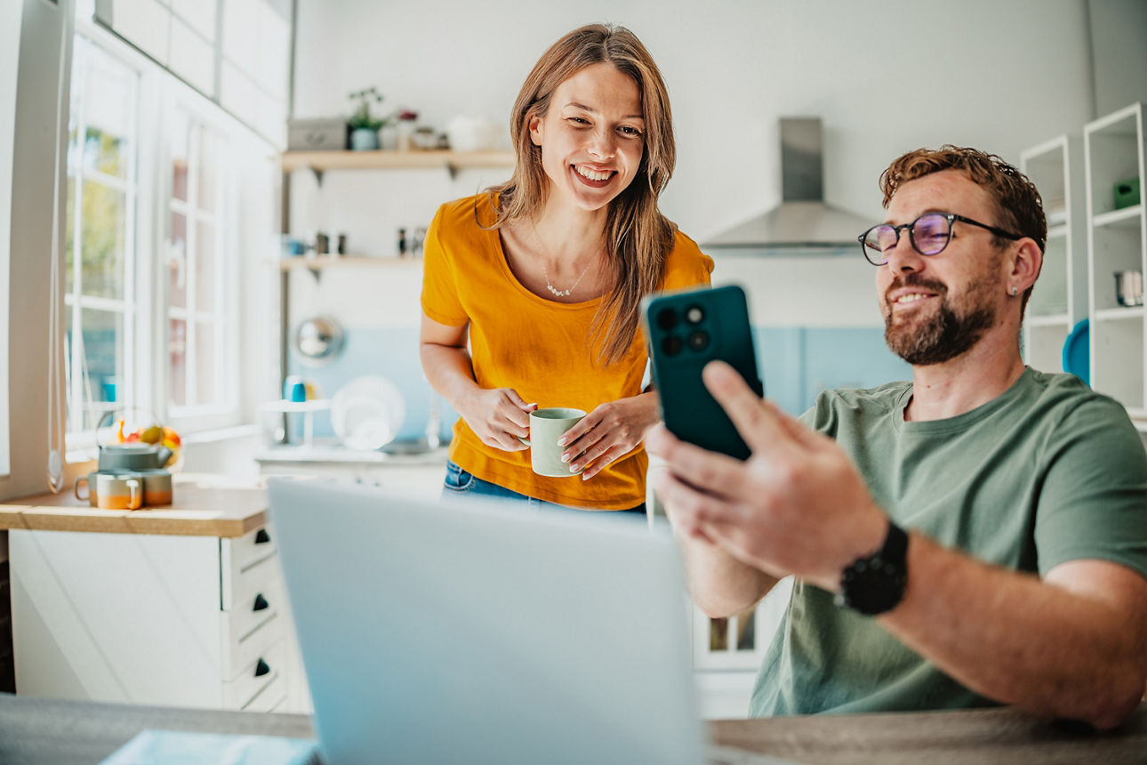 Frau und Mann schauen auf Screens und reden darüber