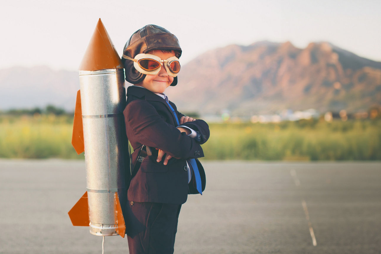Ein Junge mit Rakete auf dem Rücken und verschränkten Armen