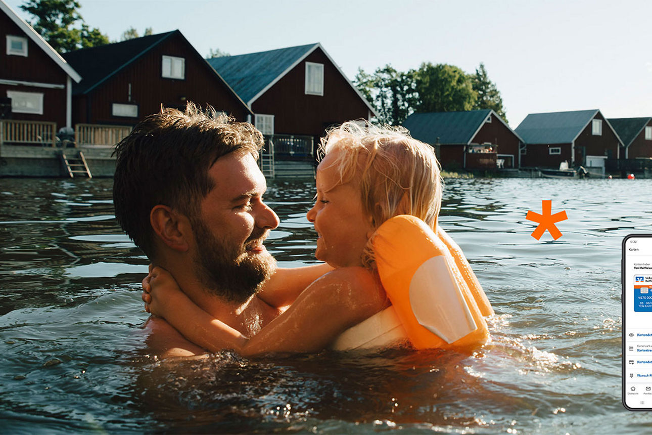 Person mit Kind im Arm im Badesee