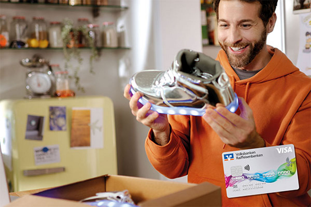 Mann mit dunklem Vollbart freut sich über neu ausgepacktem Turnschuh