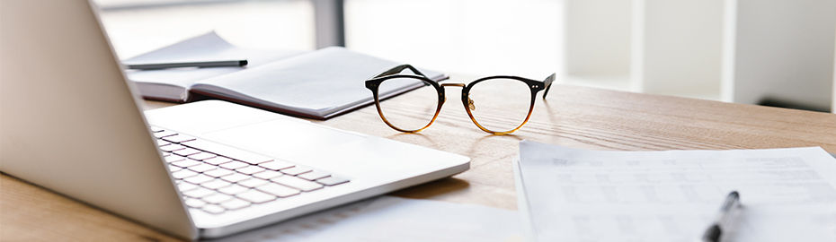 Brille in der Nähe eines Laptops
