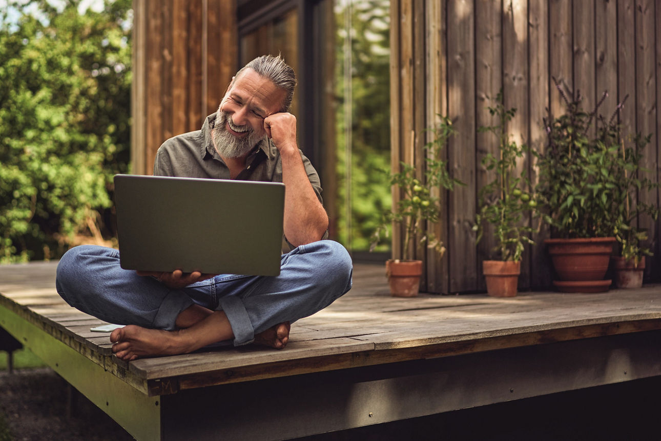 Mann arbeitet Zuhause am Laptop im eigenen Tinyhouse.