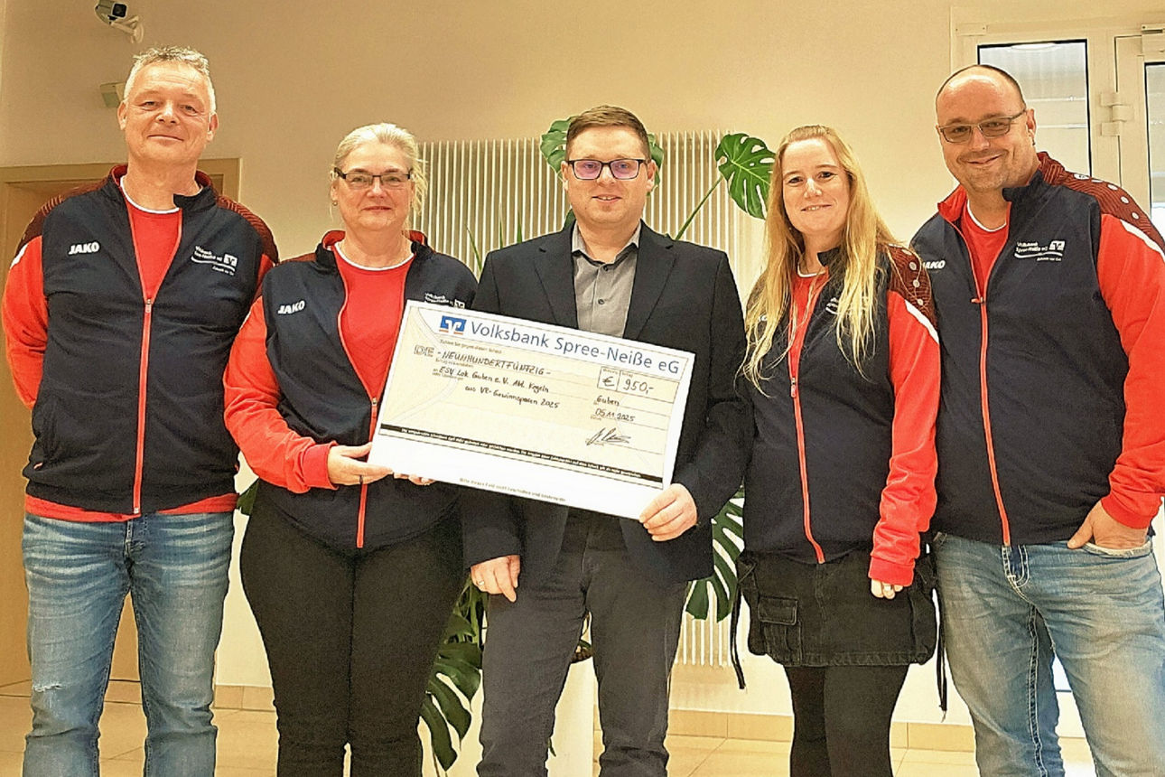 Frauen und Männer bei der Scheckübergabe