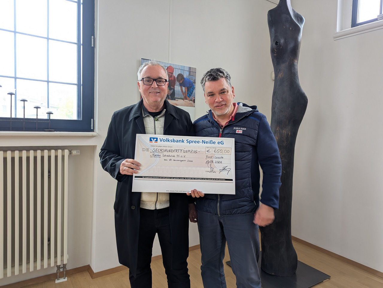 Jens Bossenz von der Volksbank Spree-Neiße eG (rechts) übergibt den Spendenscheck an Vereinsvorsitzenden des Forster  Schachclubs 95 e.V., Jürgen Goldschmidt