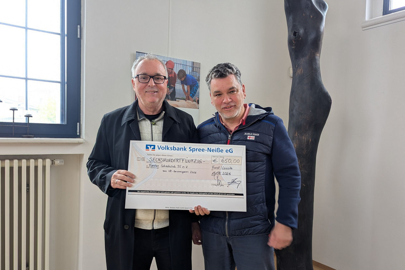 Jens Bossenz von der Volksbank Spree-Neiße eG (rechts) übergibt den Spendenscheck an Vereinsvorsitzenden des Forster  Schachclubs 95 e.V., Jürgen Goldschmidt