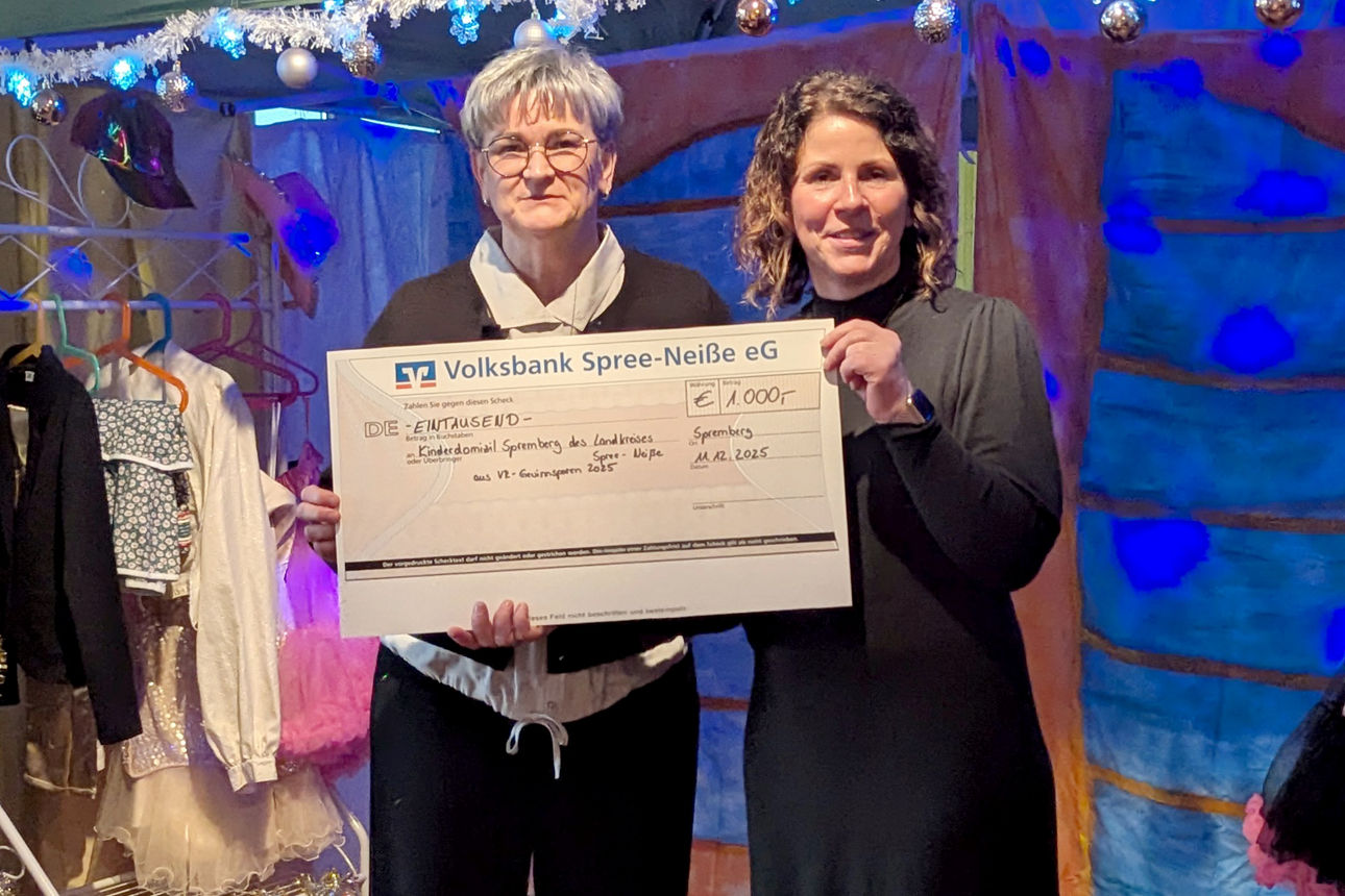 Zwei Frauen halten einen großen Scheck in den Händen