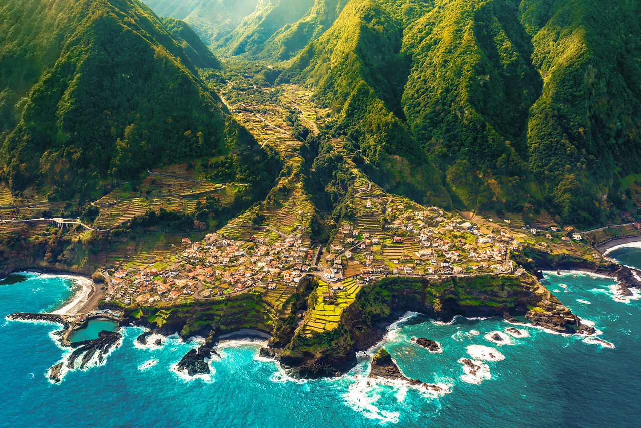 Eine malerische Bucht zwischen zwei Bergen, indem ein Dorf liegt. Dieses liegt auf Madeira.