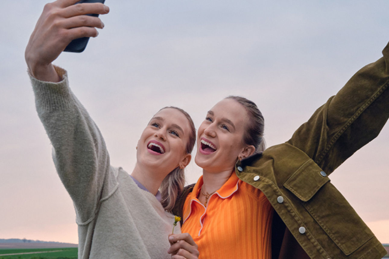 Happy girlfriends are walking and hugging in the city and make fun together