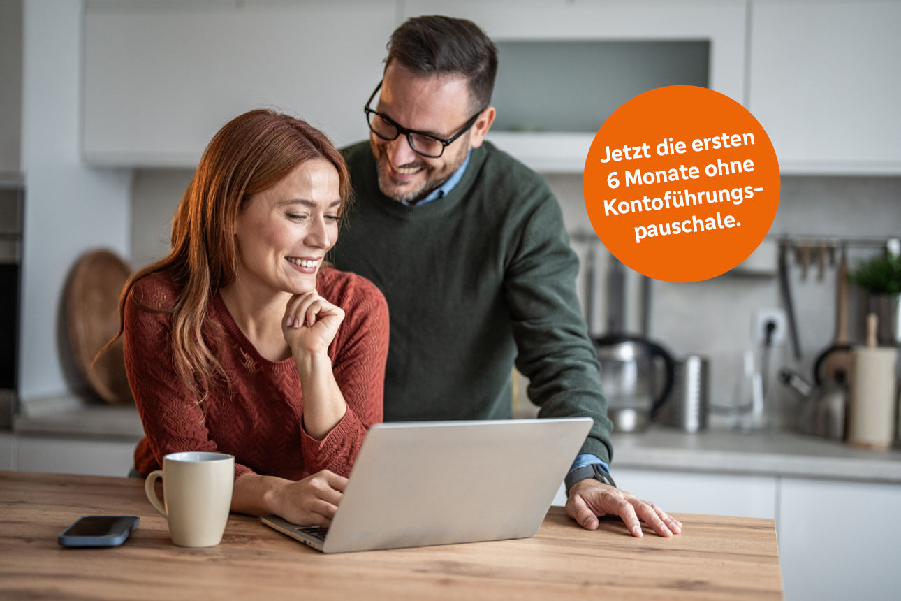 Frau und Mann schauen auf den Laptop vor ihnen - Störer mit Text "Jetzt die ersten 6 Monate ohne Kontoführungspauschale."