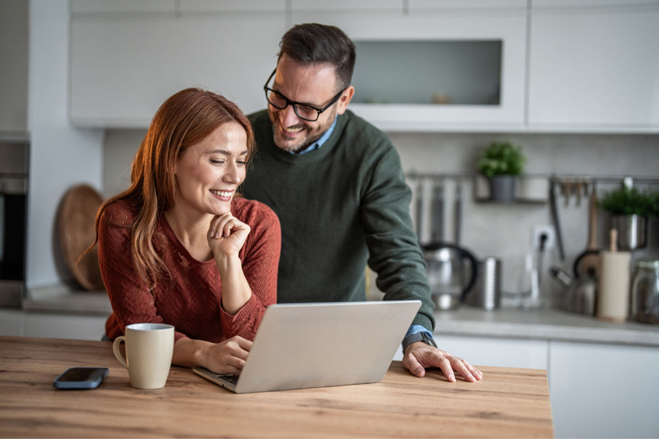 Frau und Mann blicken auf Laptop 