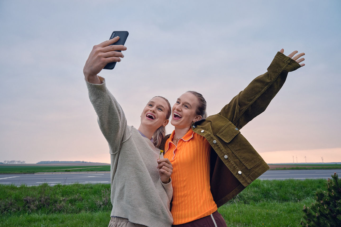 Happy girlfriends are walking and hugging in the city and make fun together