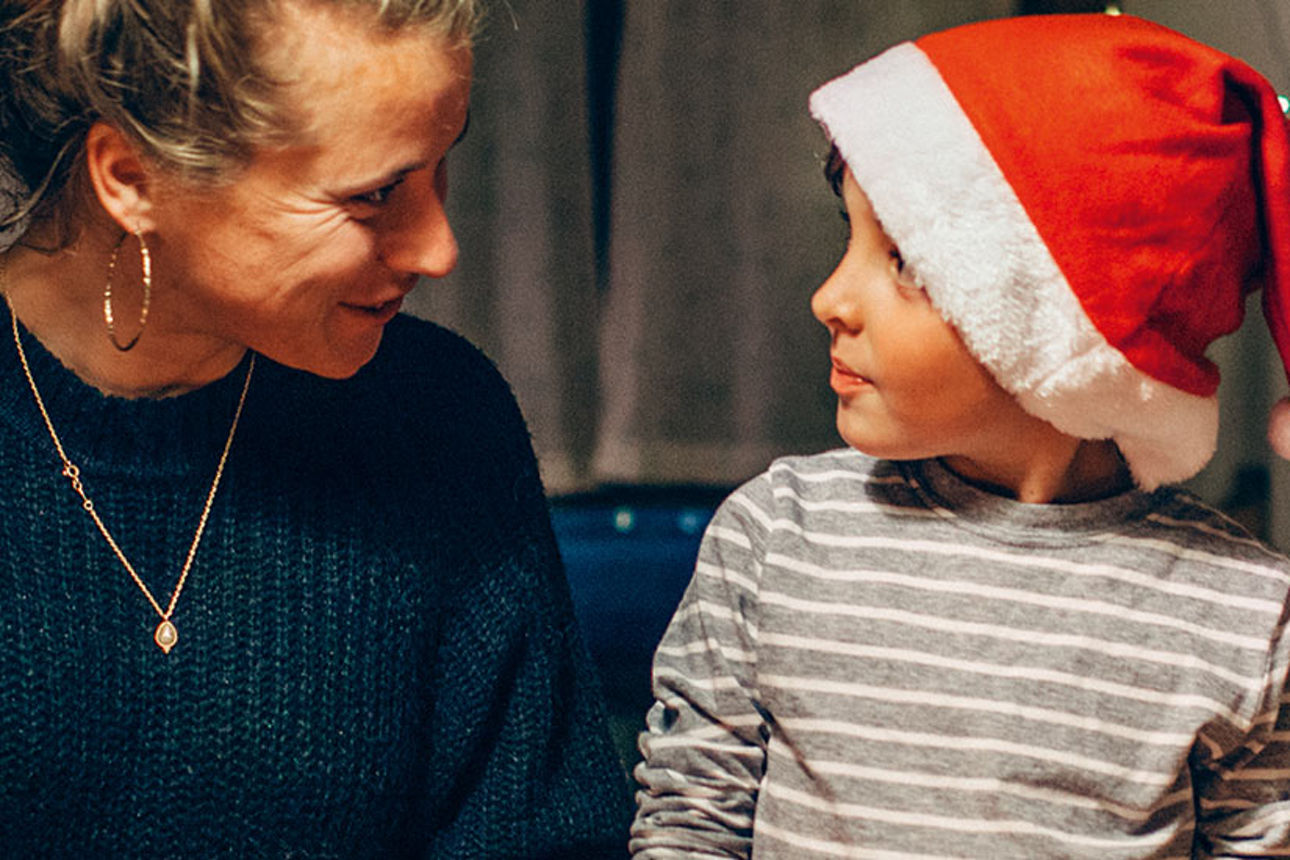 Junge mit Nikolausmütze bei 2 Frauen