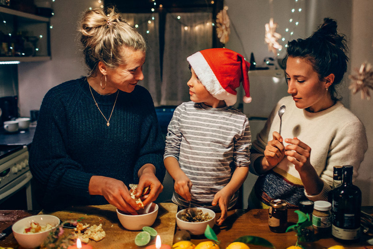 In der Küche backt die Mutter mit ihren beiden Kindern Plätzchen.