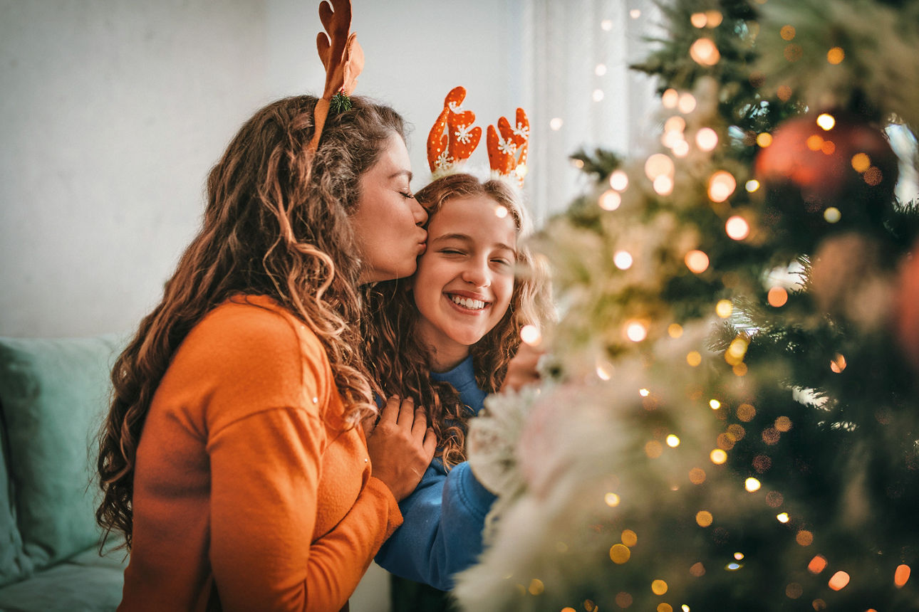 2 Mädchen vor geschmücktem Weihnachtsbaum