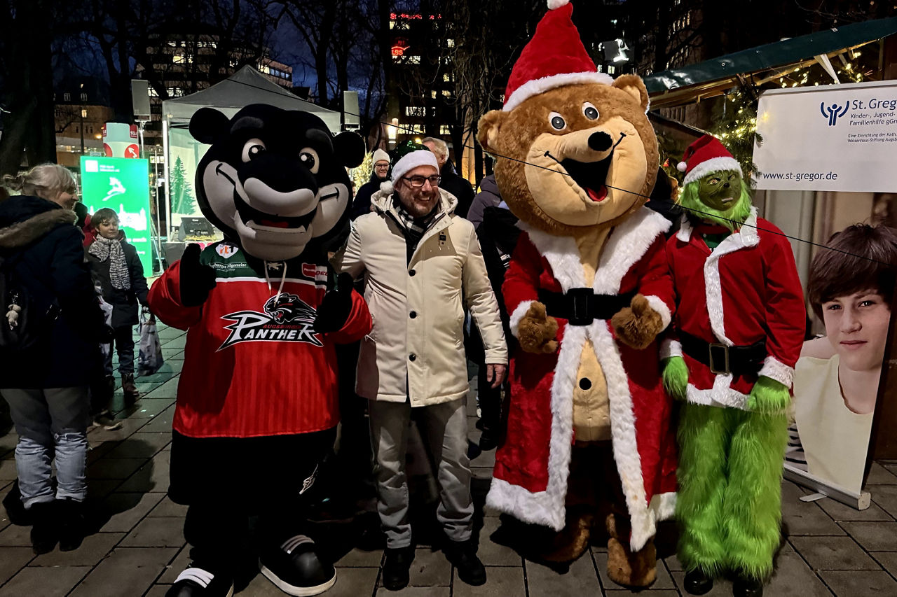 PSD-Vorstand Thomas Palus umringt von den Maskottchen Grinch, dem Weihnachtsbär und dem AEV-Datschi.