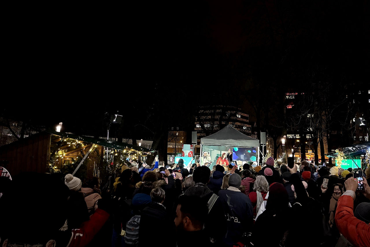 Leyla singt auf dem Augsburger Königsplatz Weihnachtslieder umgeben von einem mitsingenden Publikum.