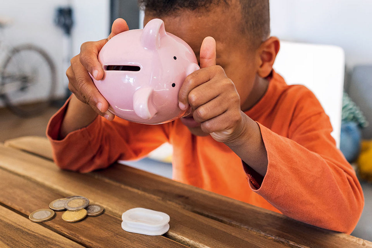 Ein Junge leert sein Sparschwein