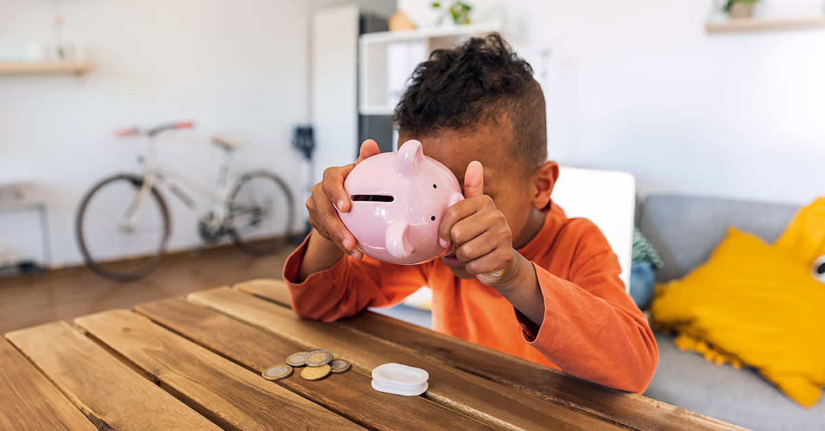 Kind mit Sparschwein in der Hand