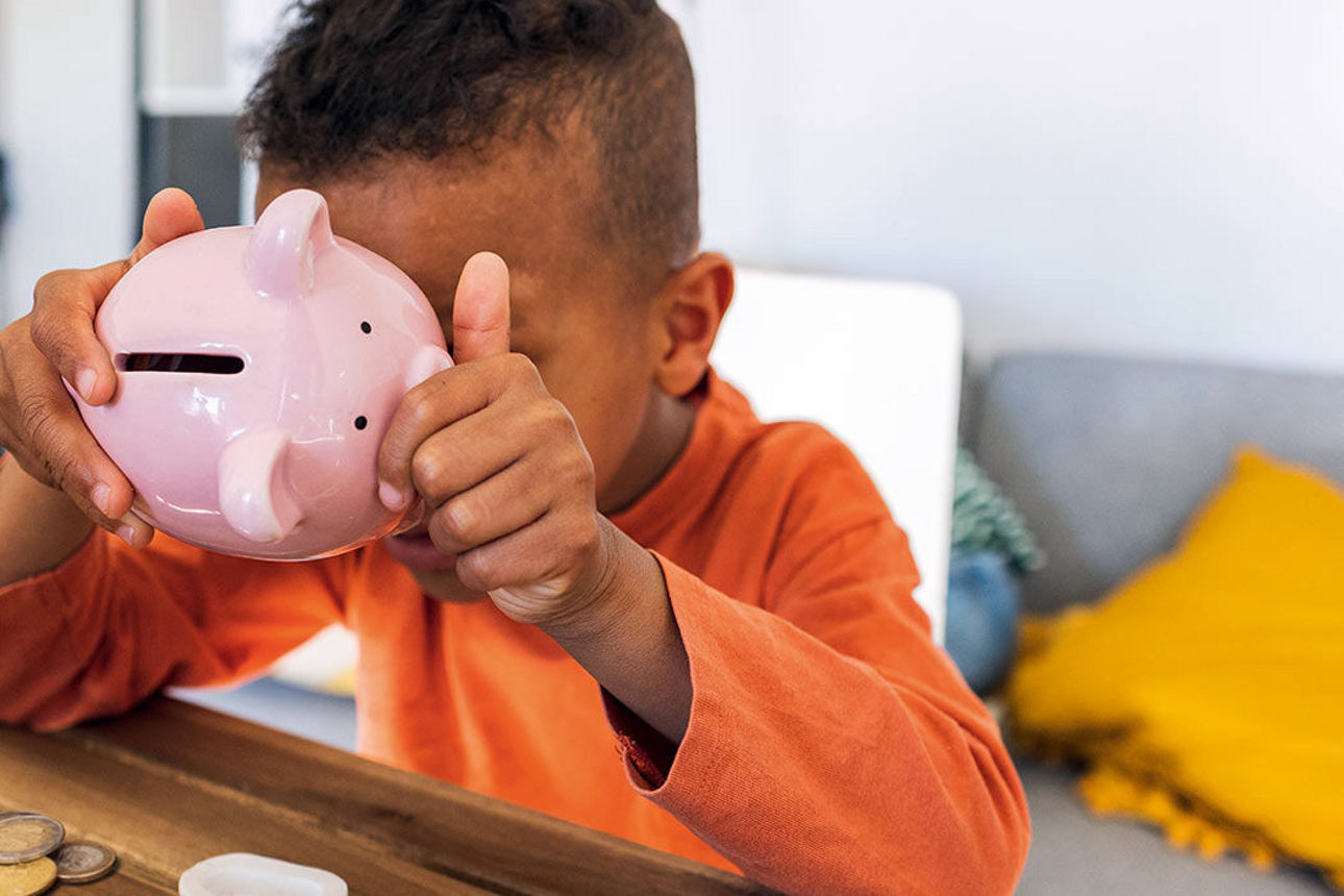 Kind hält Sparschwein in der Hand 