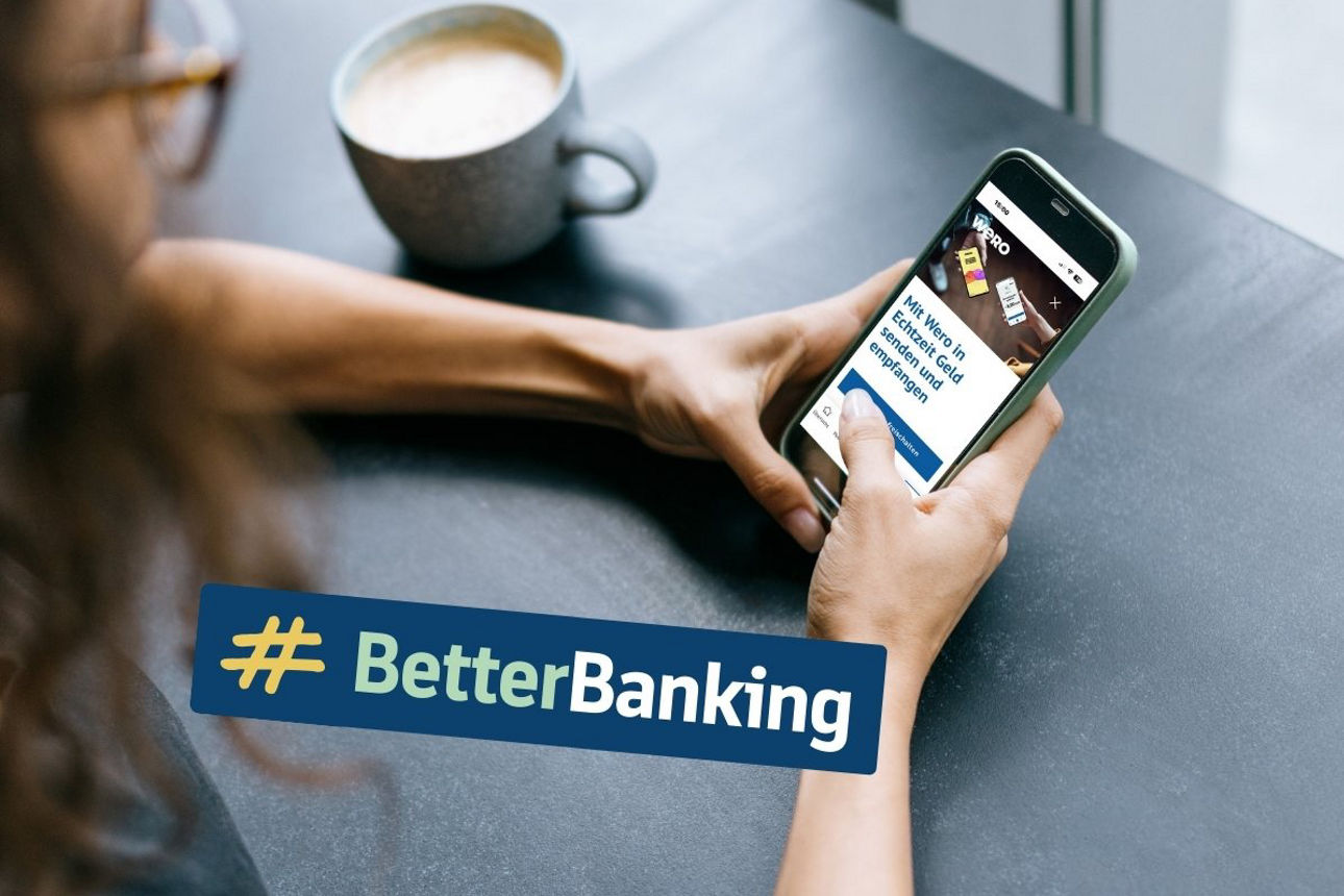 Frau sitzt an Tisch und hält vor sich ein Smartphone in den Händen