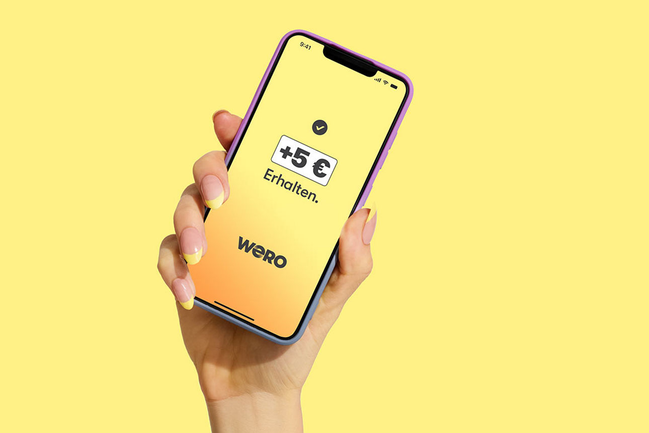 Eine Hand hält ein Smartphone, das eine Ansicht von Wero zeigt.