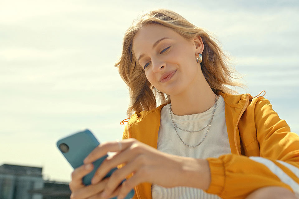Eine junge Frau nutzt Wero auf ihrem Smartphone