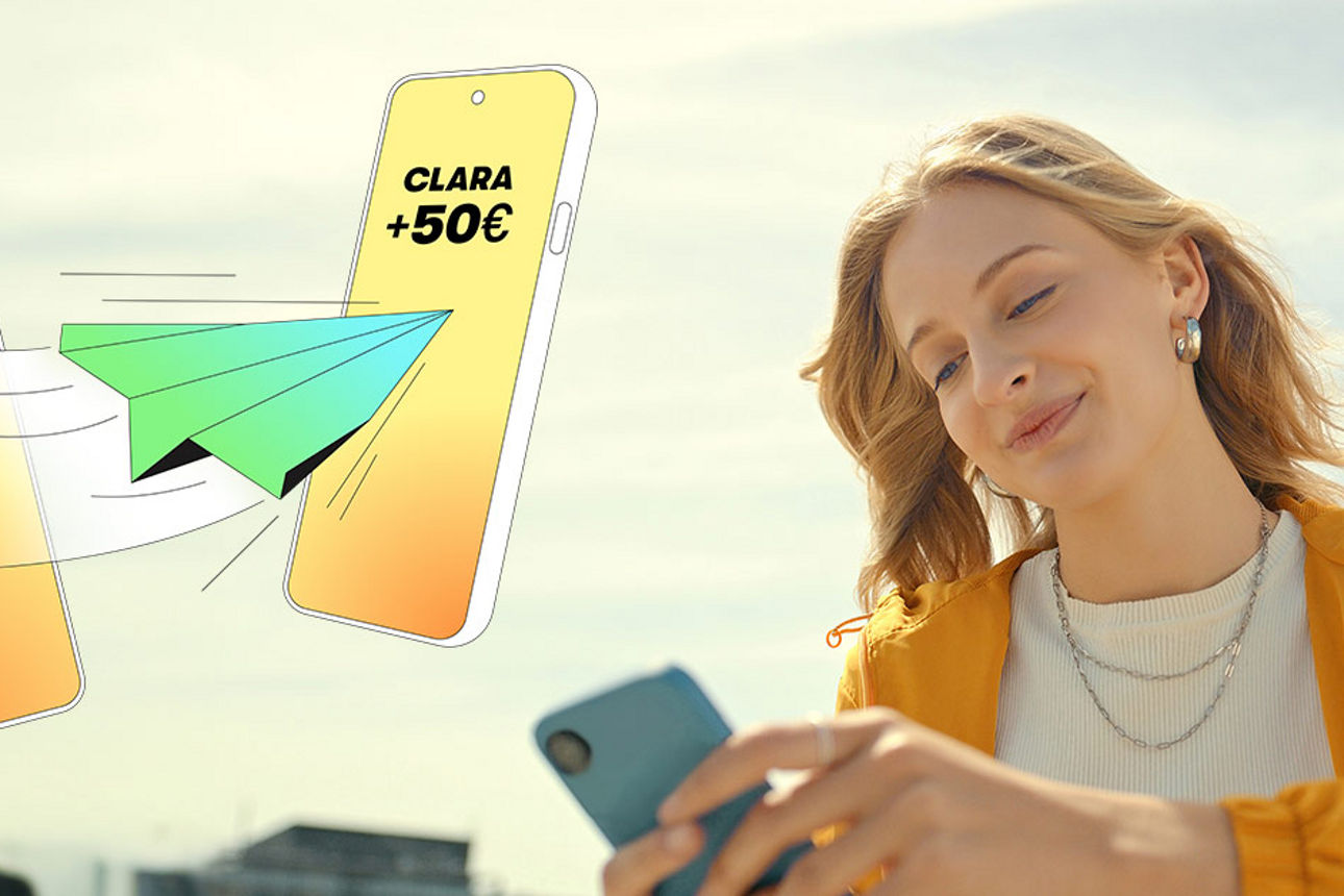 Junge Frau schaut lächeldn auf ihr Smartphone