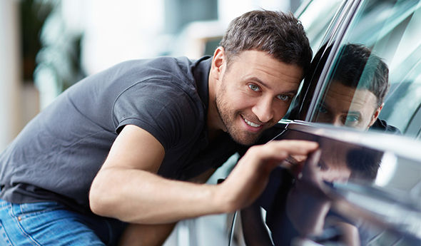 Mann wirft Blick auf Autolack