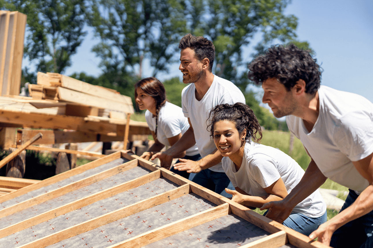 Team baut gemeinsam ein Holzdach.