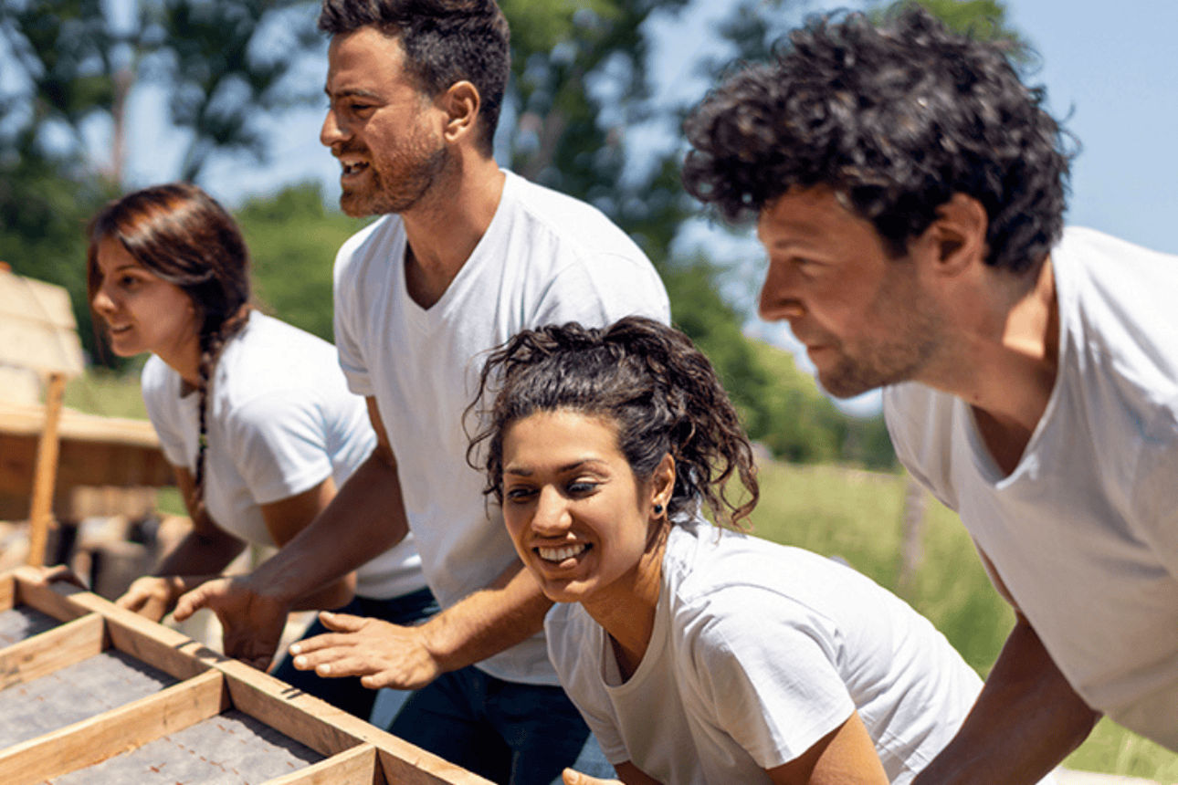 Team baut gemeinsam ein Holzdach.