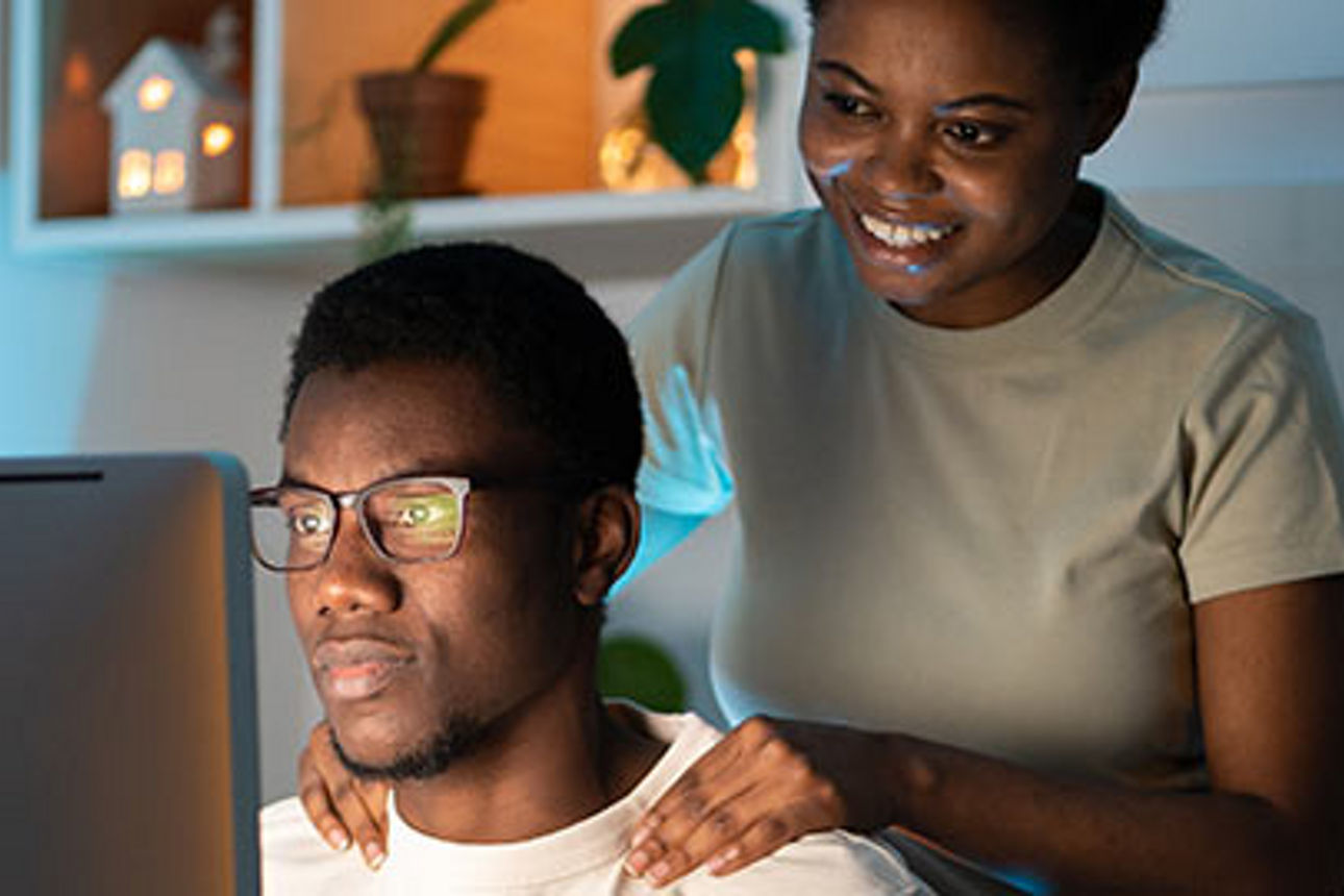 Ein Mann und eine Frau sitzen vor einem Computerbildschirm