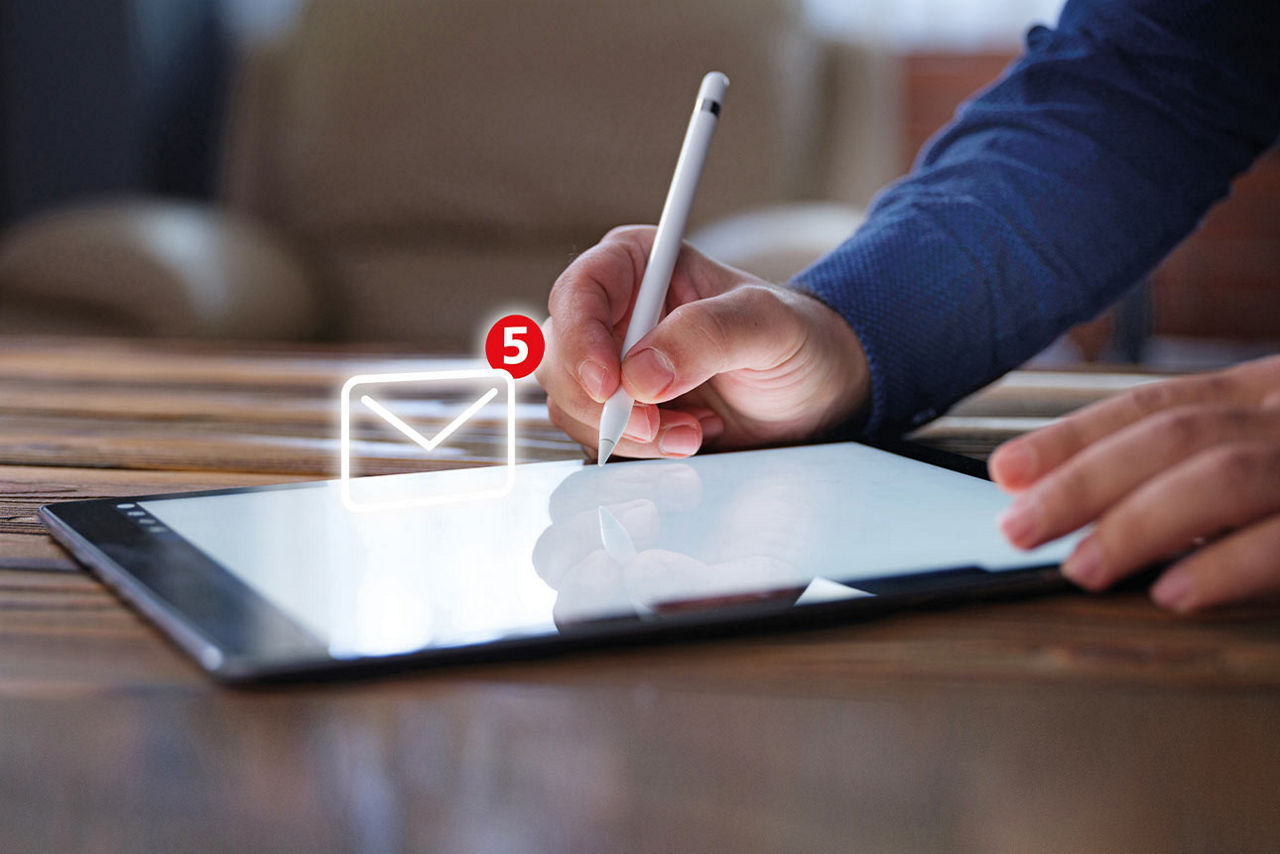 Mann schreibt mit Stift auf Tablet