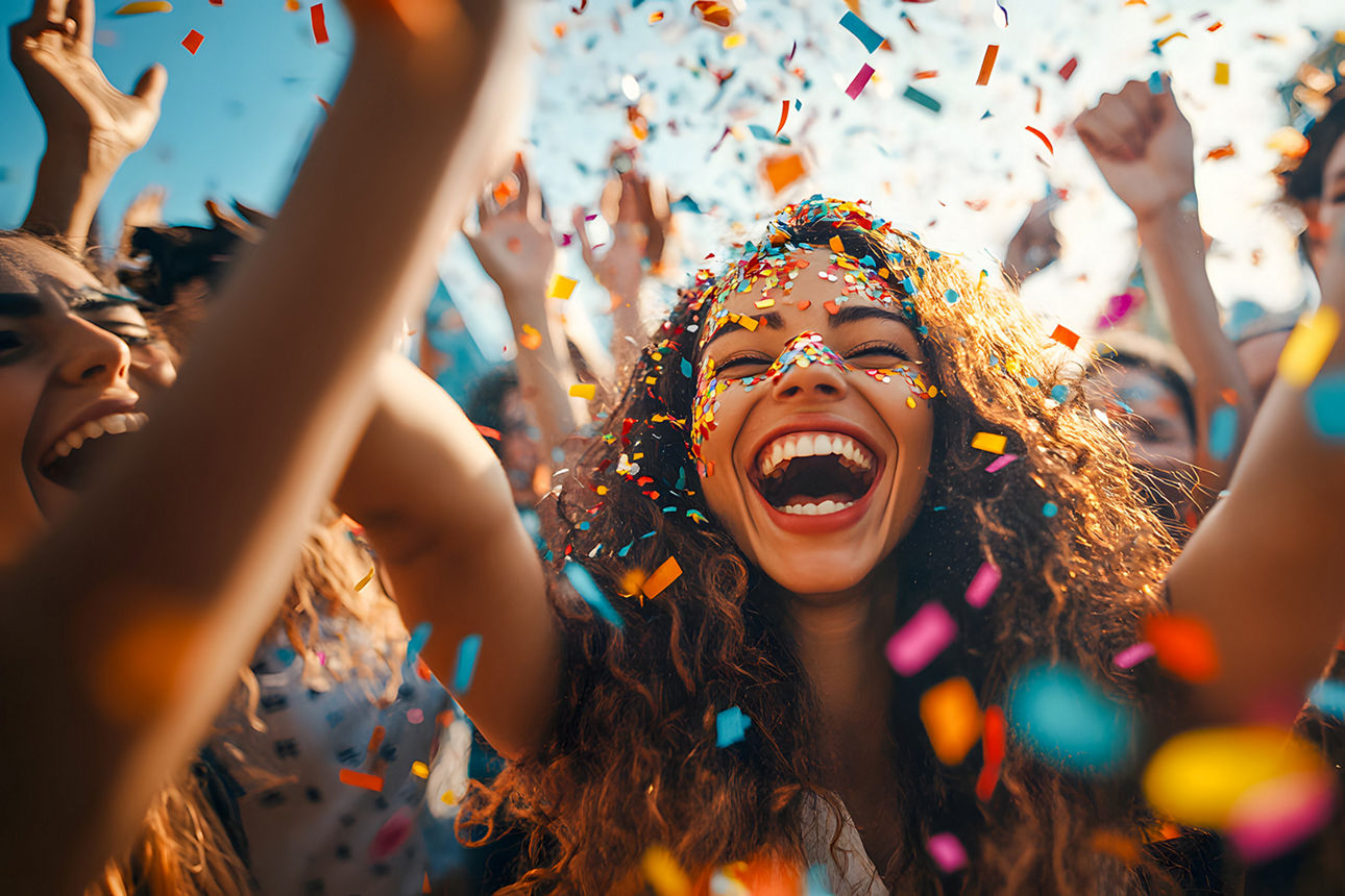 Gruppe feiernder junger Menschen im Konfettiregen.