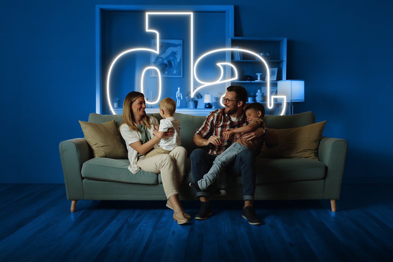 Familie sitzt gemeinsam auf der Couch.