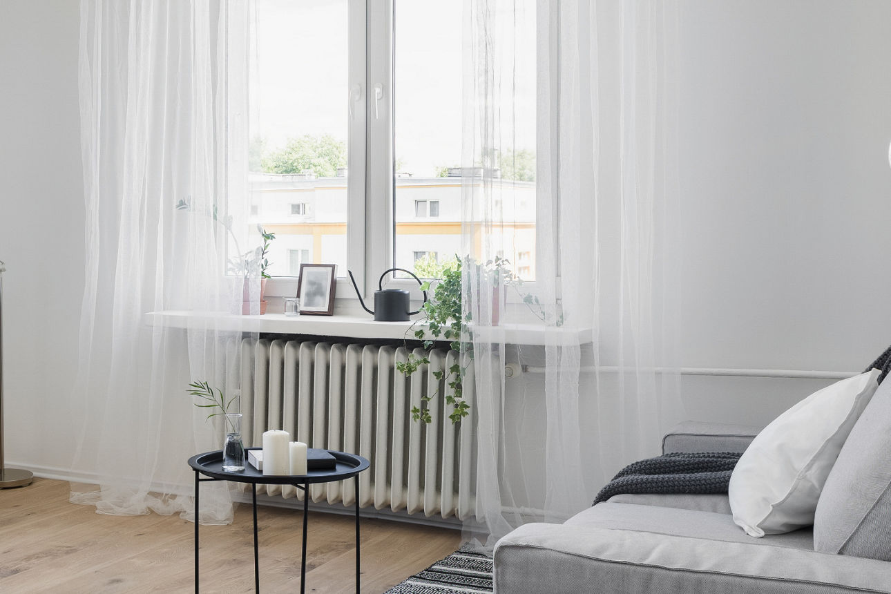 Ein Pärchen steht mit den Rücken zur Kamera und blickt auf ein Einfamilienhaus