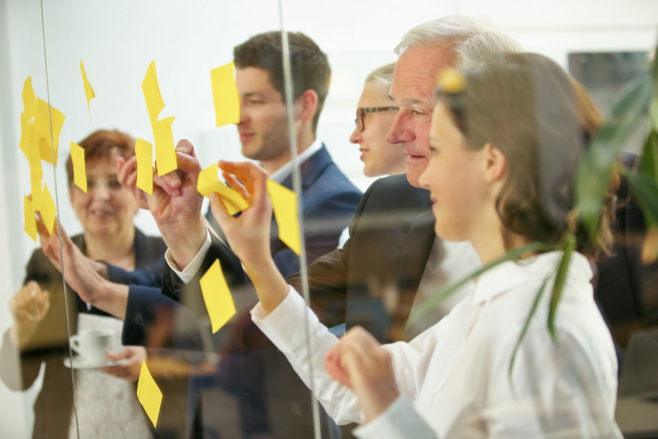 Mehrere Personen arbeiten während eines Workshops mit Post-Its