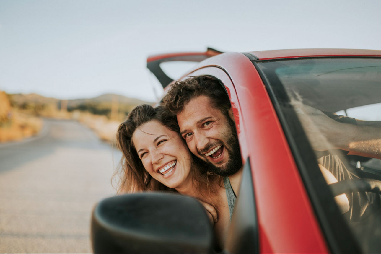 Junges Paar im Urlaub schauen aus dem Beifahrerfenster hinaus