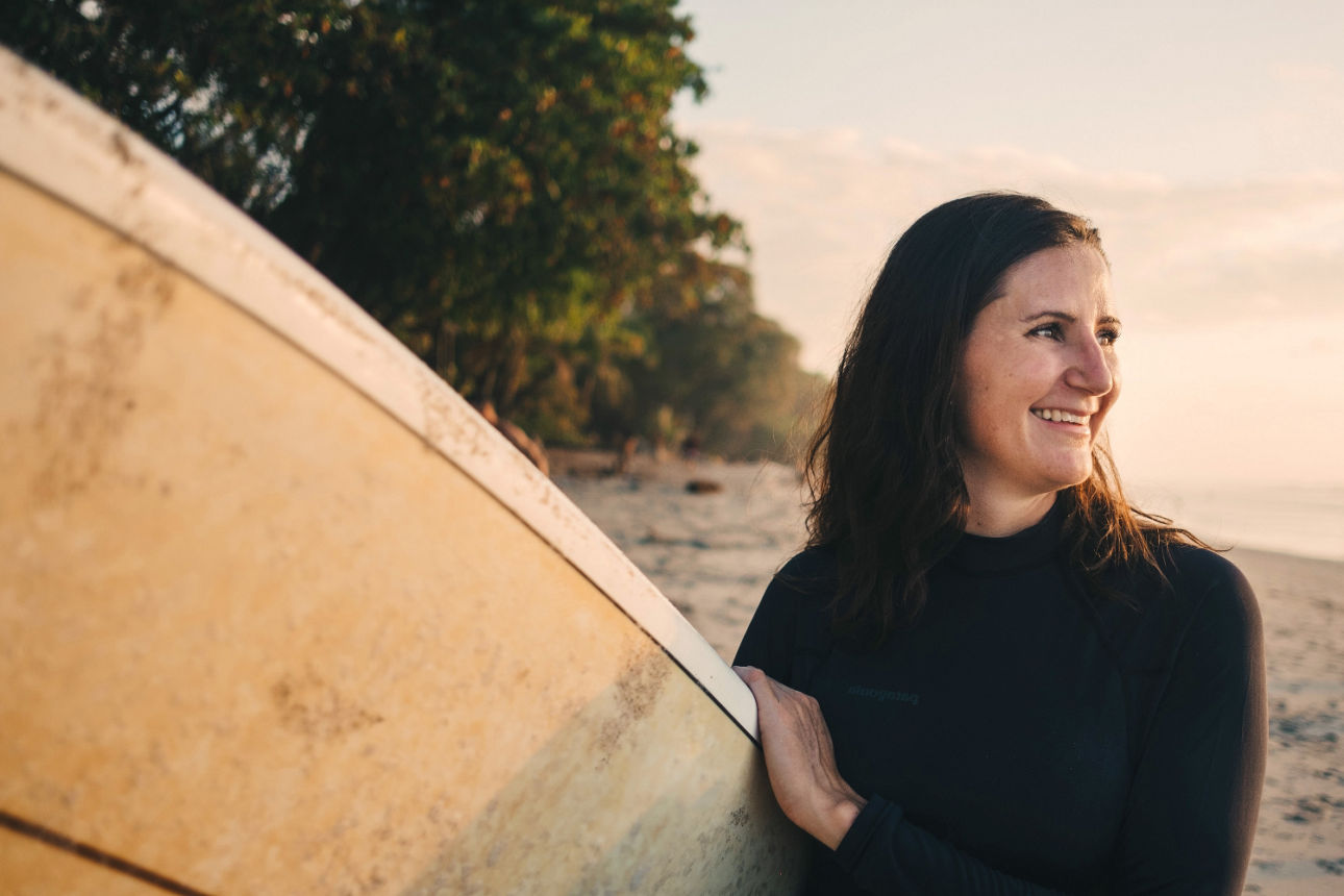 Junge Frau mit Surfbrett am Meer
