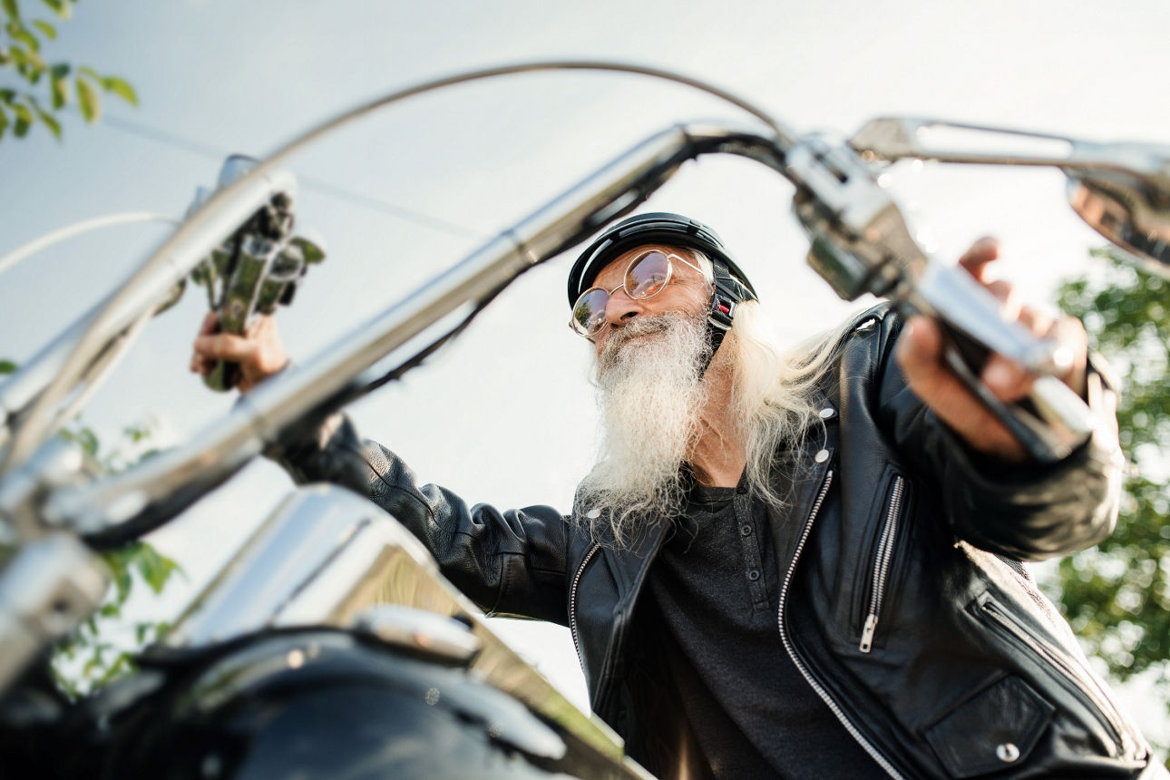 Rocker mit weißem langen Bart auf dem Motorrad