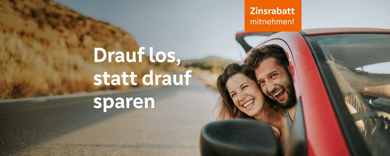 Ein fröhliches Paar lehnt sich aus einem roten Auto auf einer sonnigen Straße und lacht.