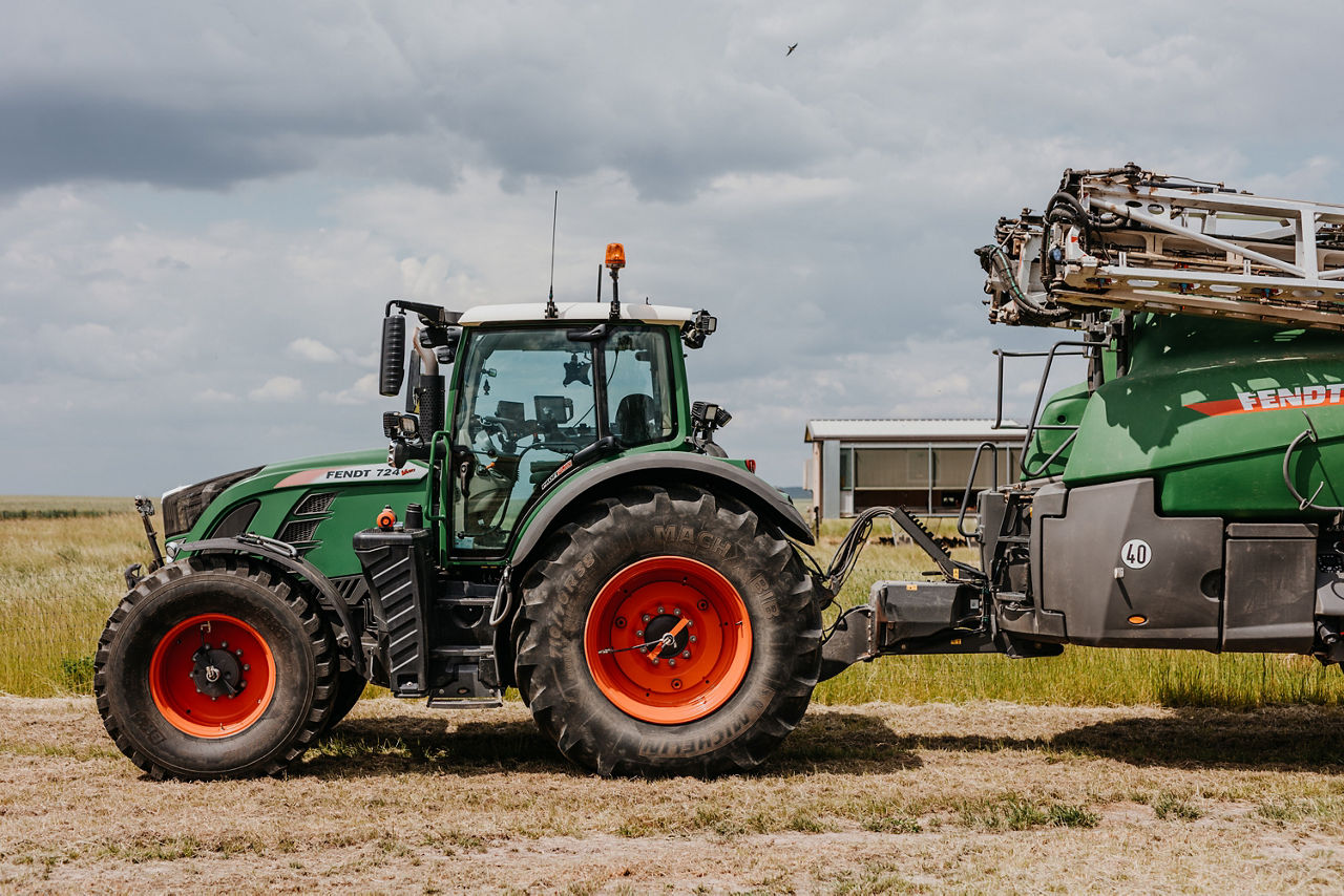 Ein Traktor pflügt ein staubiges Feld