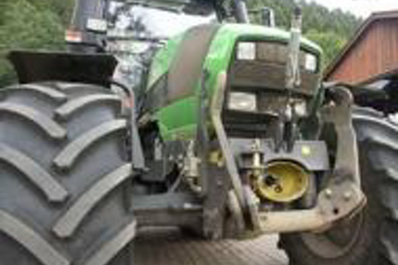 Foto eines grünen Traktors mit Betonung auf den großen Vorderrädern