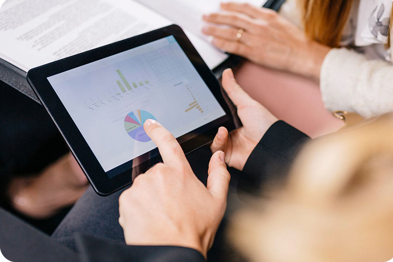 Ein Tablet mit Statistiken in einem Paar Hände