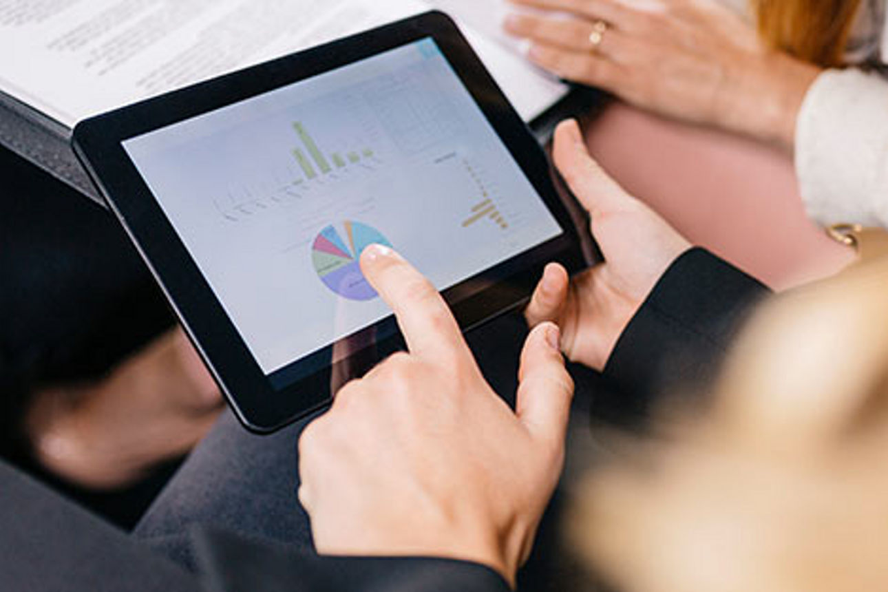 Ein Tablet mit Statistiken in einem Paar Hände