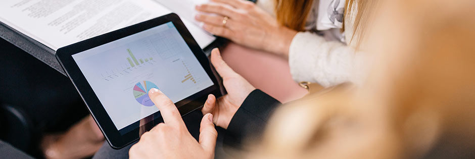 Ein Tablet mit Statistiken in einem Paar Hände
