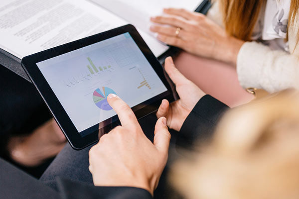 Ein Tablet mit Statistiken in einem Paar Hände