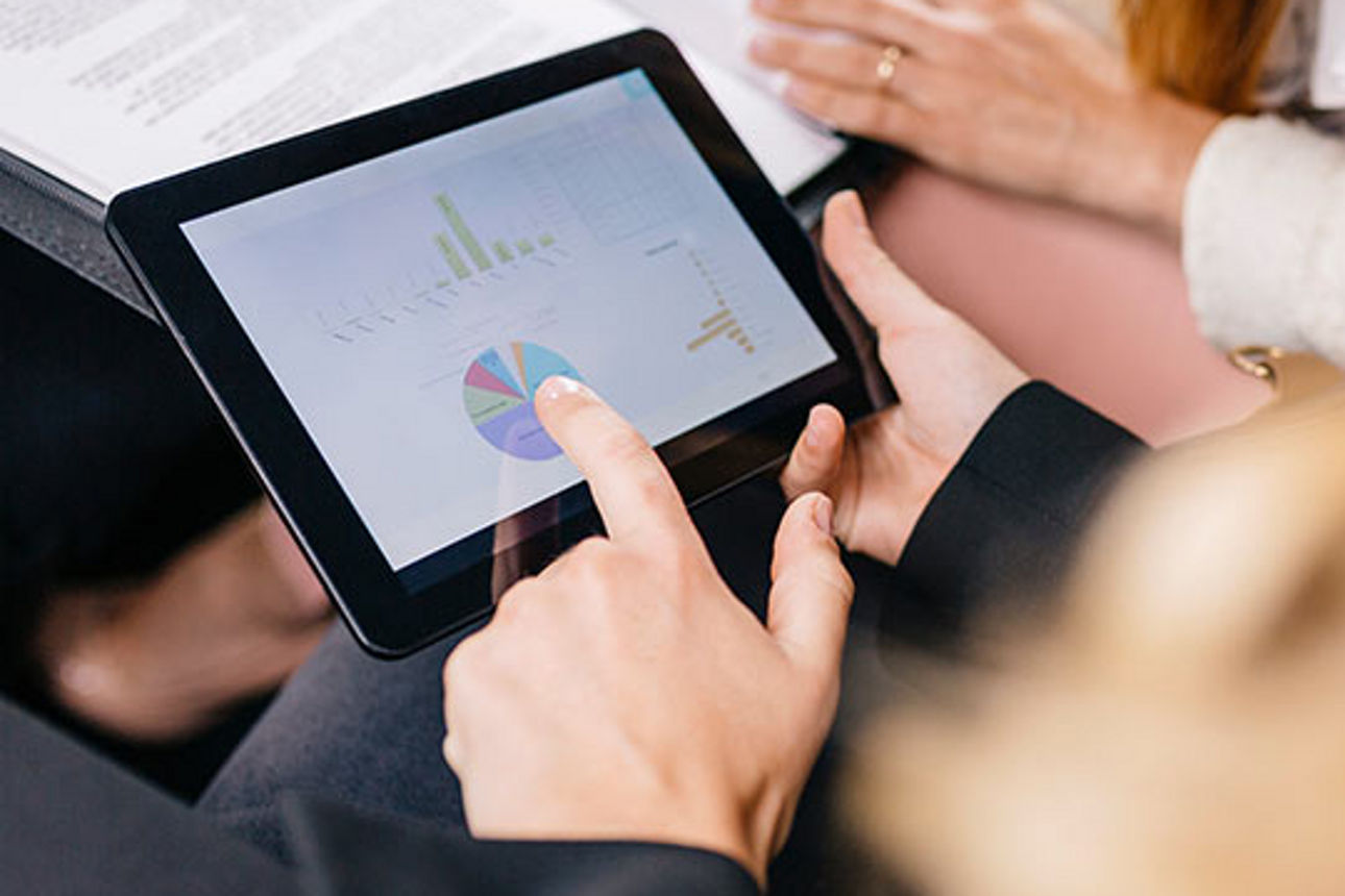 Ein Tablet mit Statistiken in einem Paar Hände