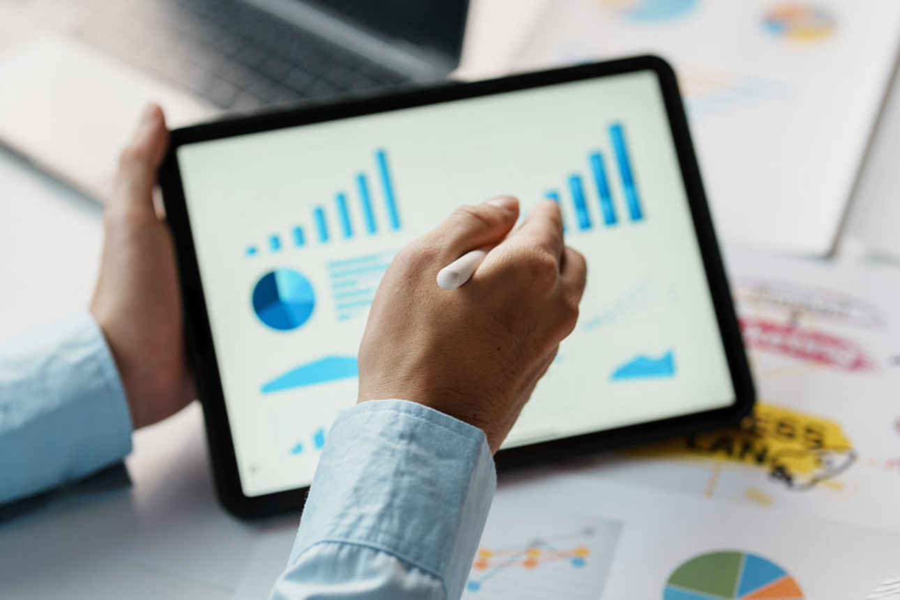 Hand zeigt auf Grafik auf einem Tablet