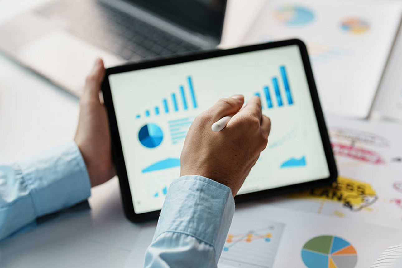 Ein Tablet mit Statistiken in einem Paar Hände