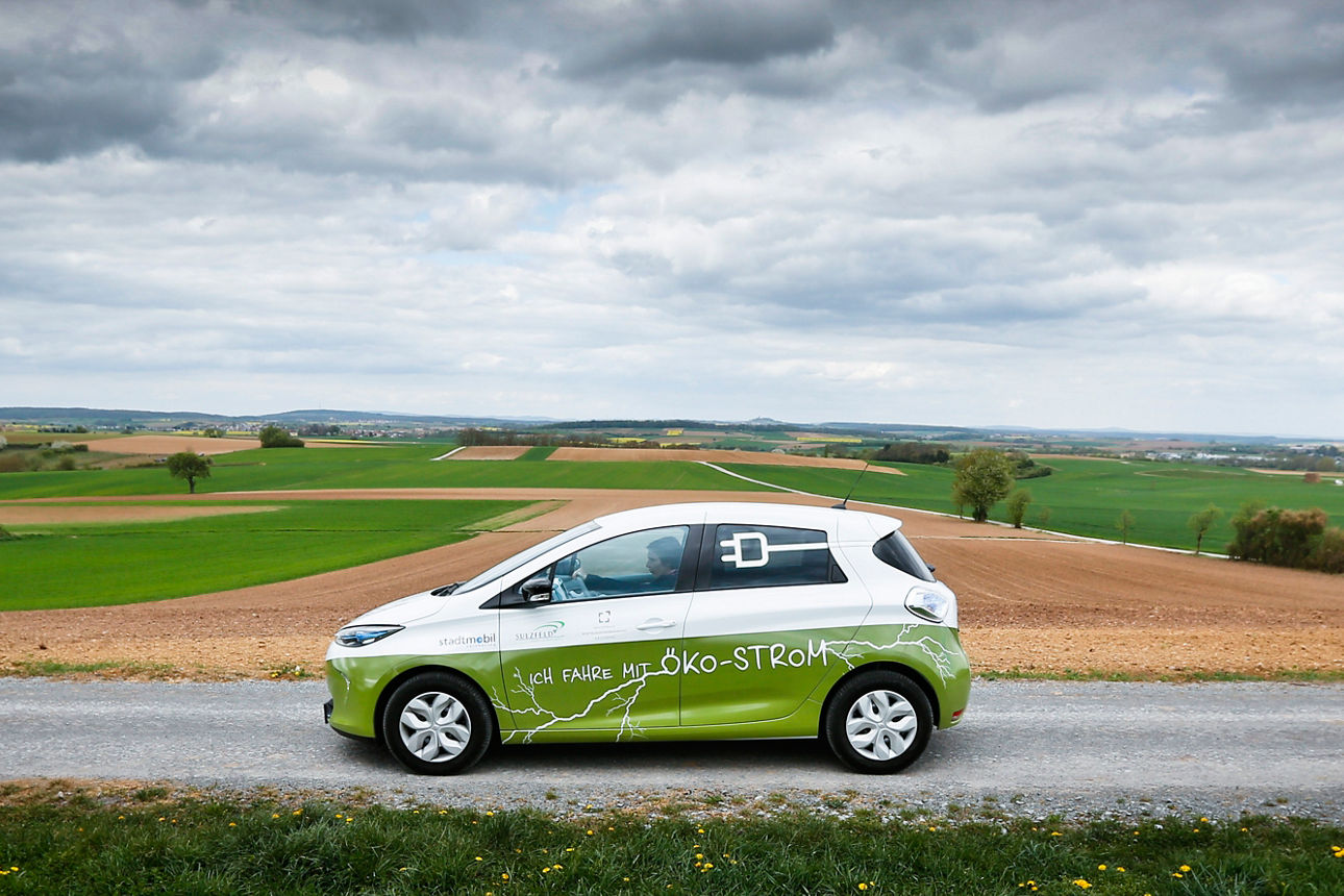 Grün-weißes Auto mit Aufschrift "Ich fahre mit Öko-Strom"